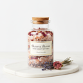 Pink aromatherapy bath salts with rose petals and lavender in a glass jar